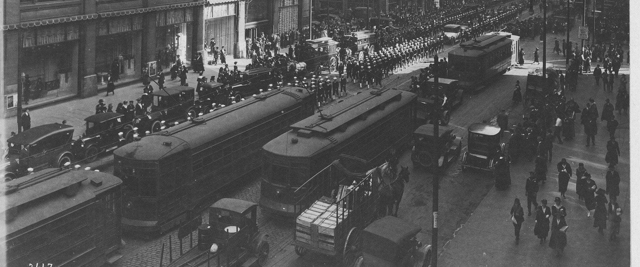 State Street, Chicago, photographed in 1917 or 1918 — streetcars, delivery wagons and a column of sailors outside the department stores.
